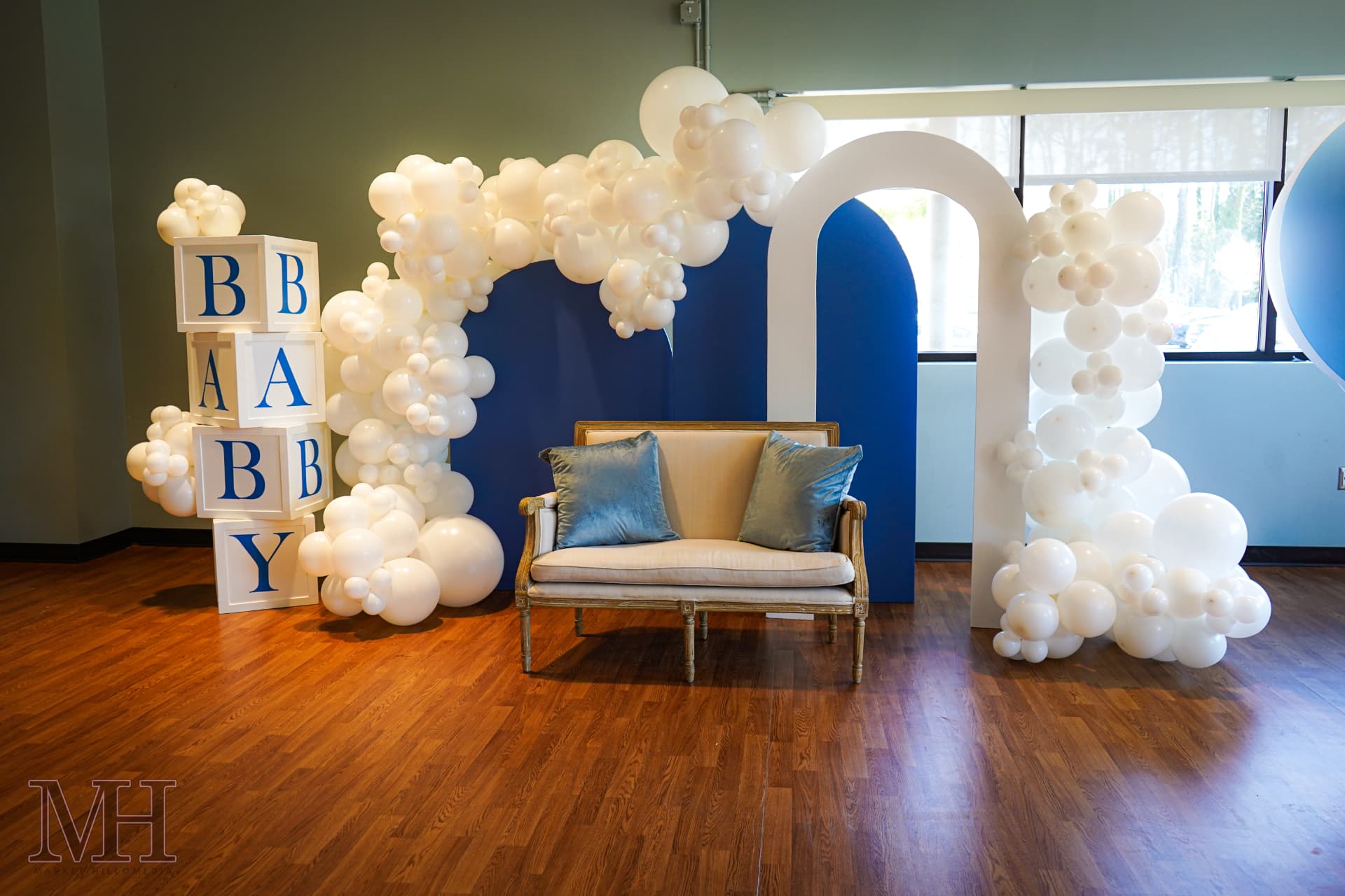 Baby shower backdrop with balloon garland and lounge seating