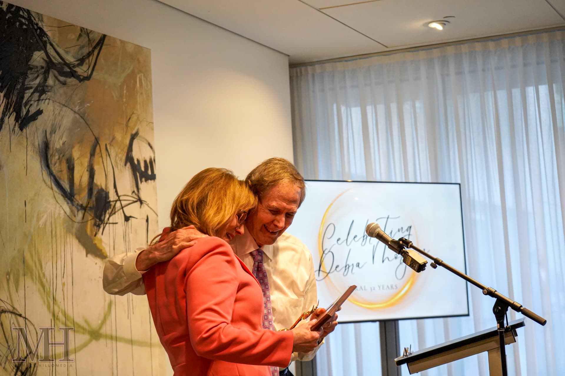 Honoree receiving an award and a hug at a retirement celebration